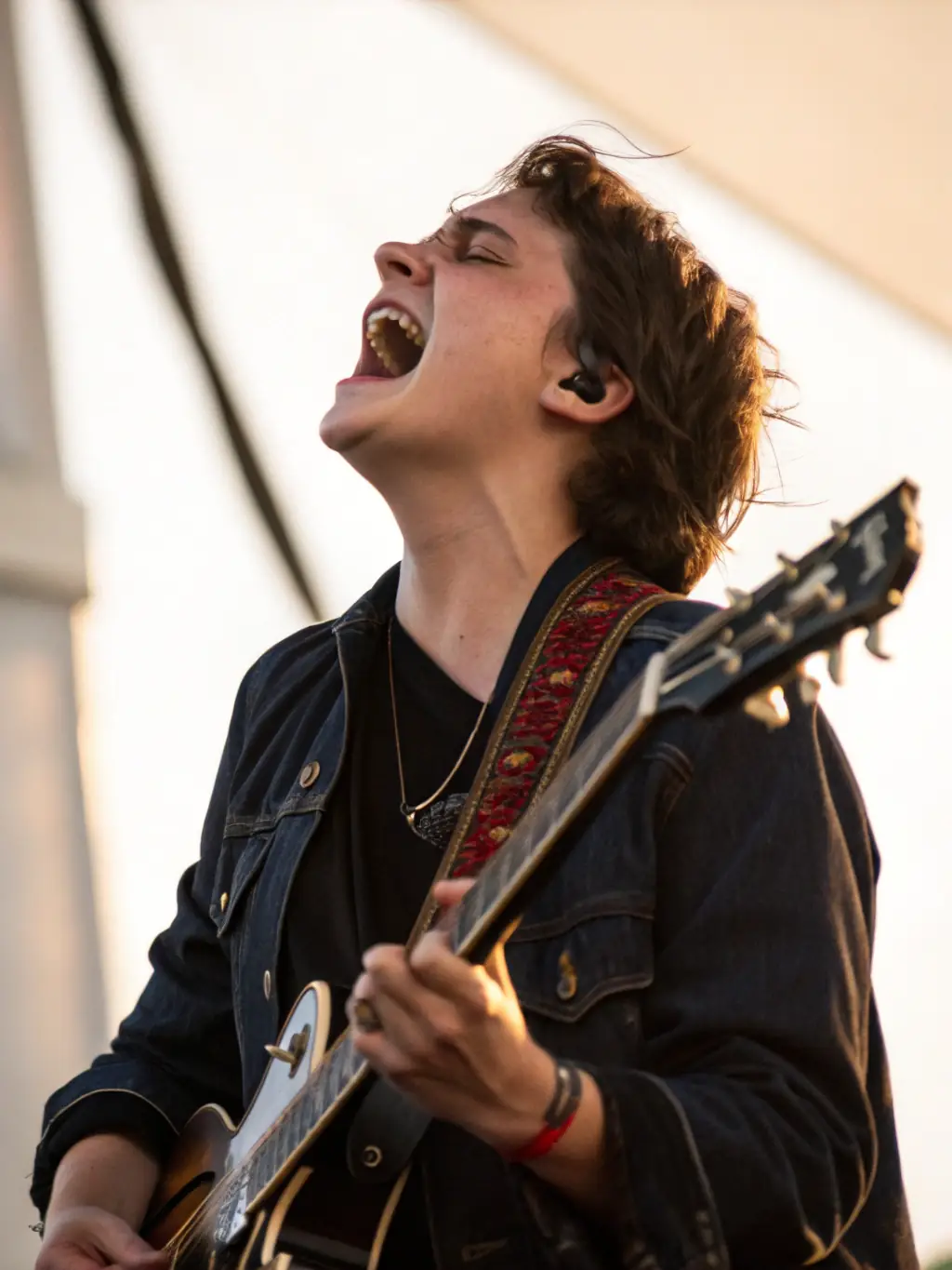 A musician passionately playing an instrument on stage during a BONJOUR MINUIT event, showcasing the organization's support for artists.